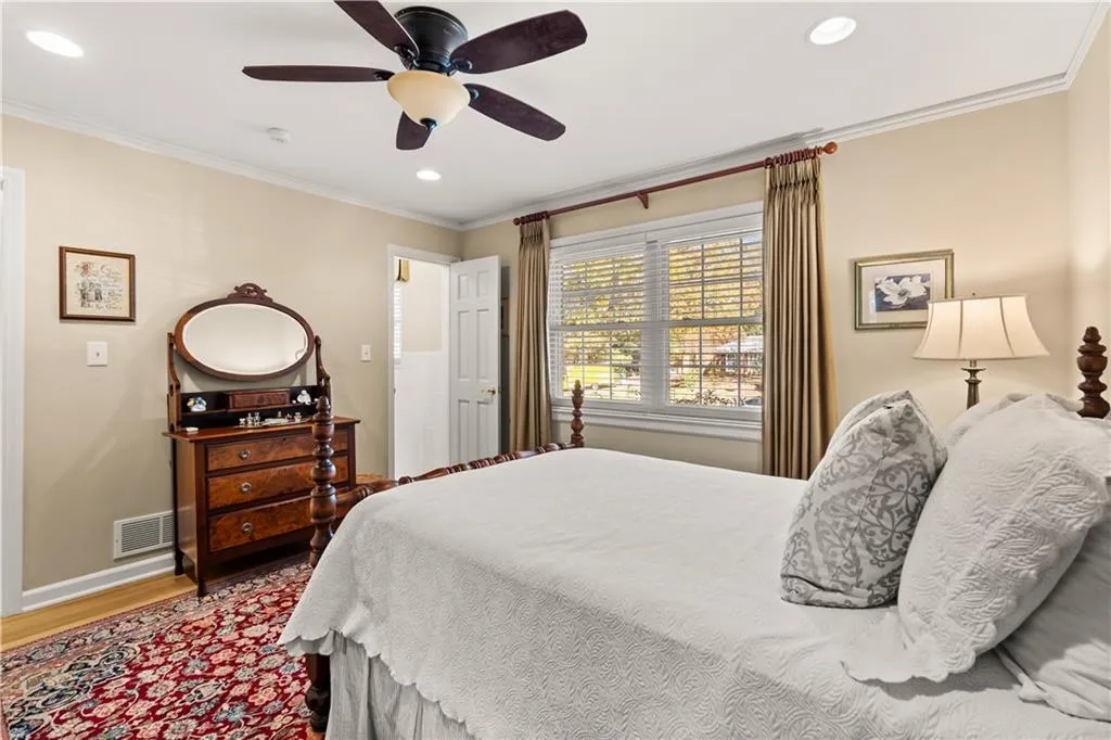 Bedroom featuring wood finished floors, a ceiling fan, crown molding, and recessed lighting