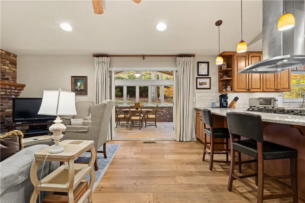 Living room with light wood-style flooring, ceiling fan, and recessed lighting