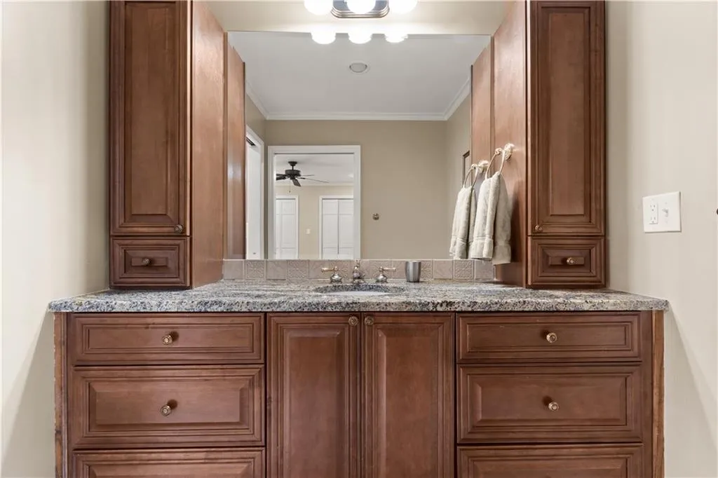 Bathroom featuring vanity, crown molding, and a ceiling fan
