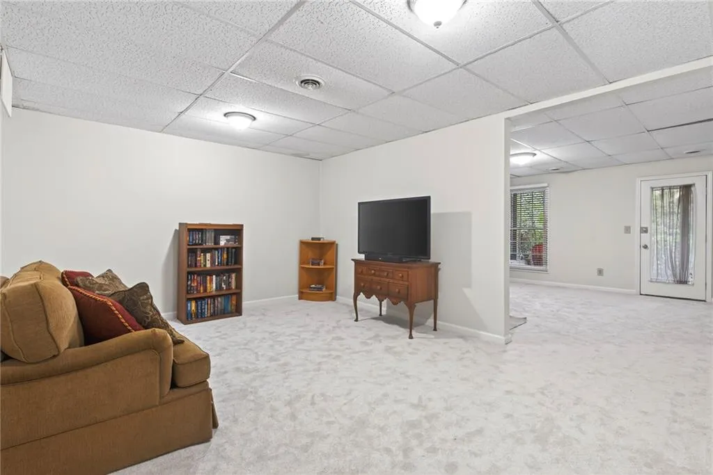 Living area featuring carpet floors and a paneled ceiling