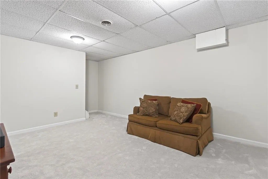 Sitting room with a paneled ceiling and light colored carpet