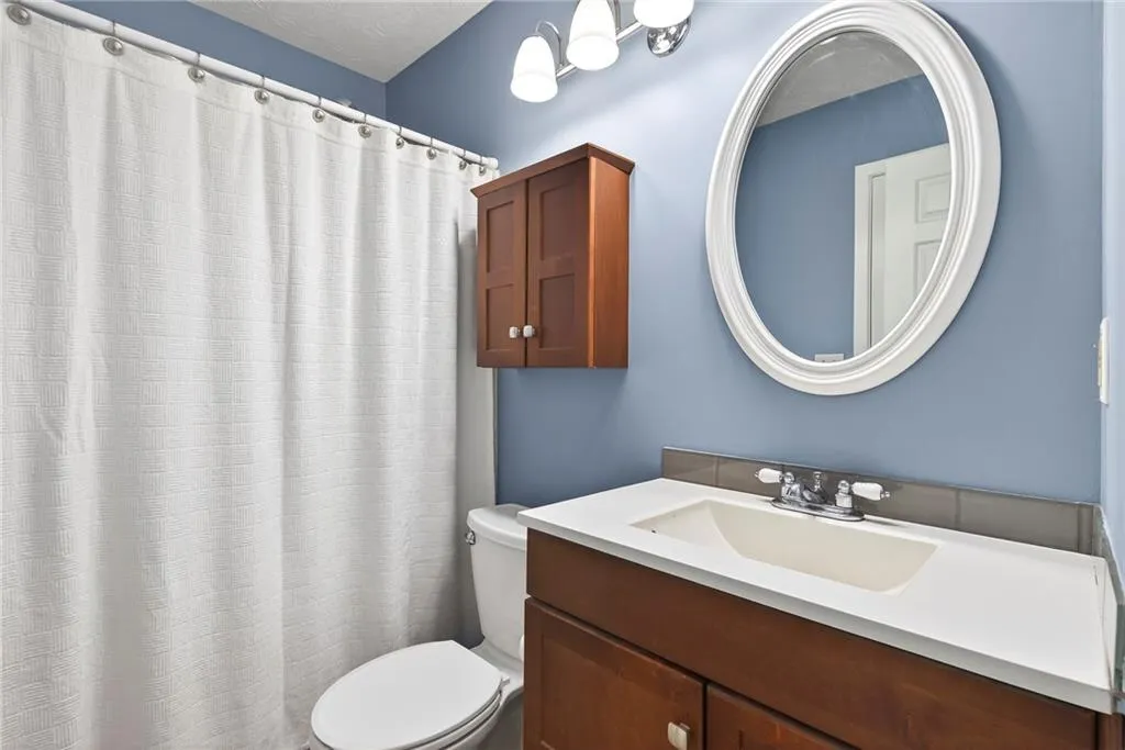 Full bath with vanity and a shower with shower curtain