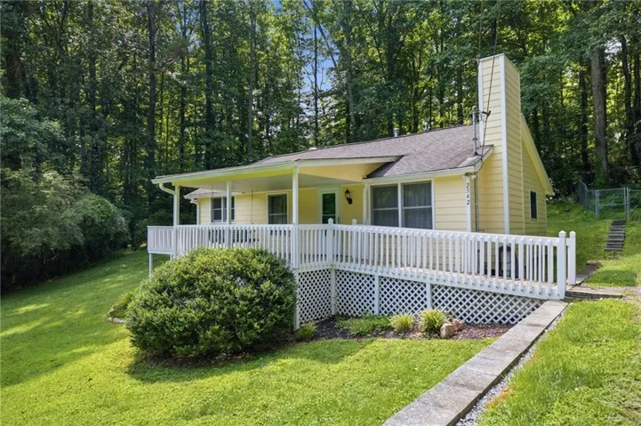 Exterior with a covered porch, white railing, and a ramp