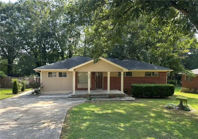 Brick and vertical siding exterior with a covered porch entry