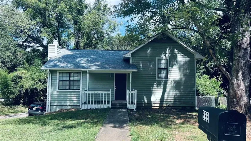Gabled exterior with horizontal siding, covered porch, and a paved walkway