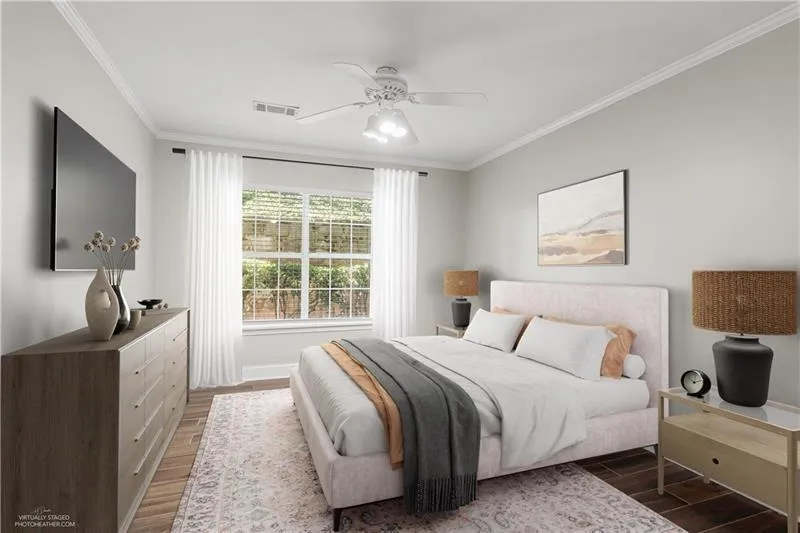 Bedroom featuring wood finished floors, crown molding, and a ceiling fan