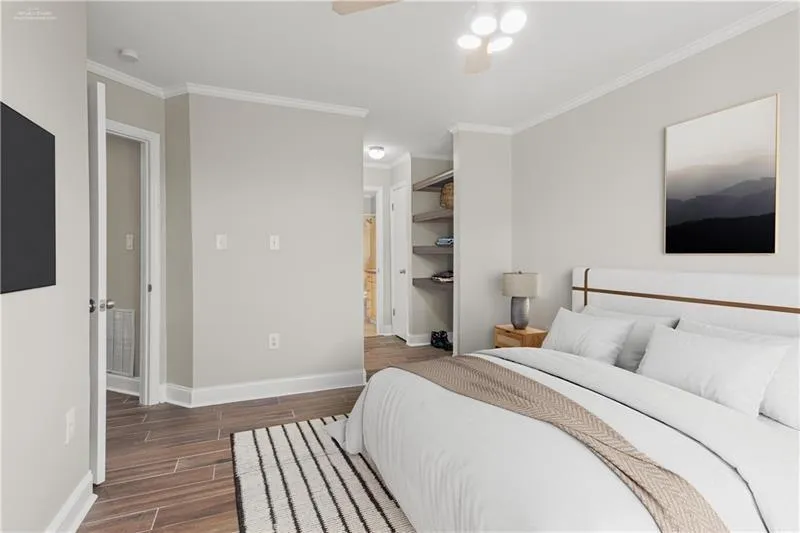Bedroom with a closet, wood finish floors, ornamental molding, and ceiling fan