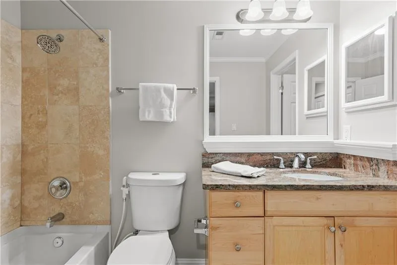 Full bathroom featuring vanity, tub / shower combination, and ornamental molding