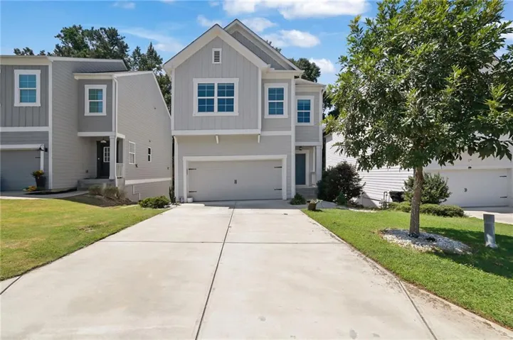 Contemporary exterior with light gray siding, white trim, and a prominent front-facing gable