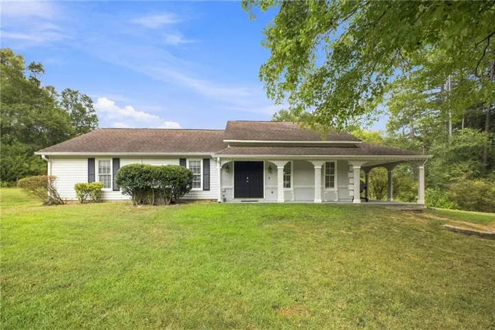 Charming single-story residence featuring a classic white exterior with black shutters and a welcoming front porch