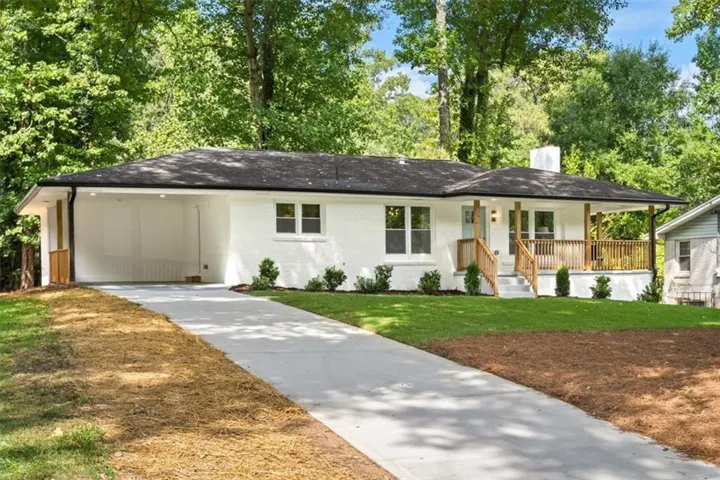 White brick exterior with a covered porch and wood railings