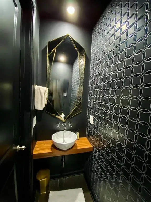 Powder Room -Designer Wall Tile with vessel sink and floating walnut wood top, custom lighting
