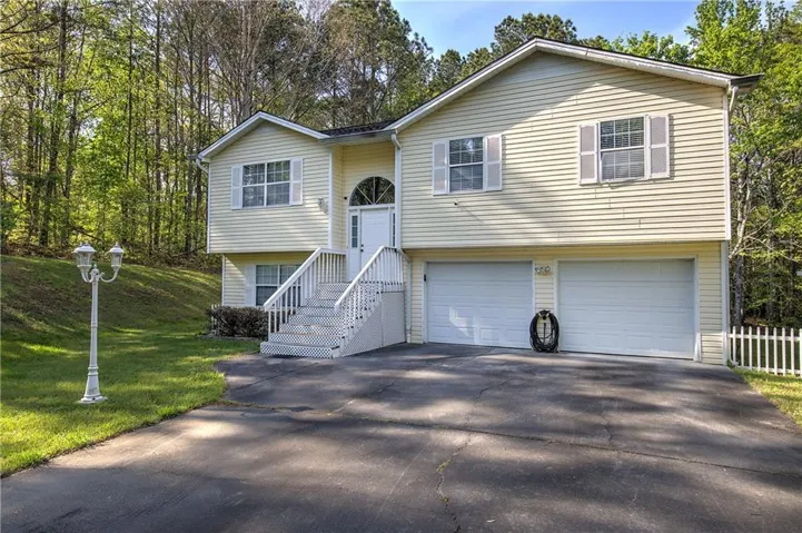 Split foyer home with a garage, asphalt driveway, and a front lawn