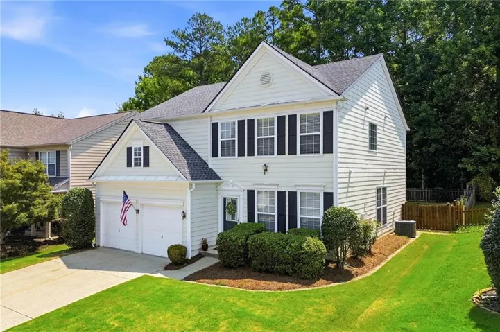 Two-story residence featuring white-colored siding, a dark shingle roof, and a two-car garage