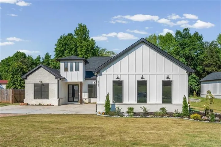 Contemporary exterior with white board and batten siding, dark trim, and a prominent front entry tower