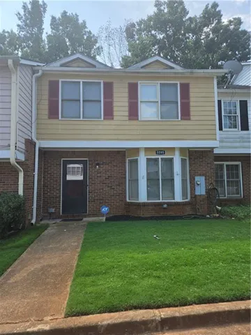 Brick and siding exterior with red shutters