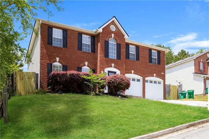 Brick exterior with white trim, arched window accents, and a dual garage