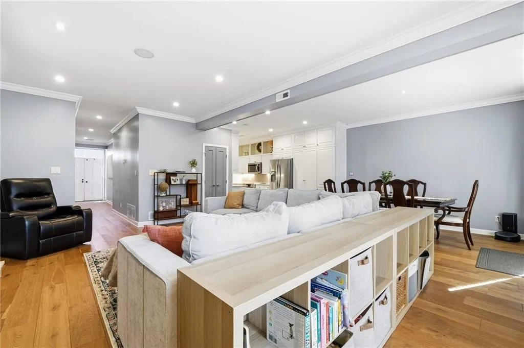 Living area with crown molding, light wood-style flooring, and recessed lighting