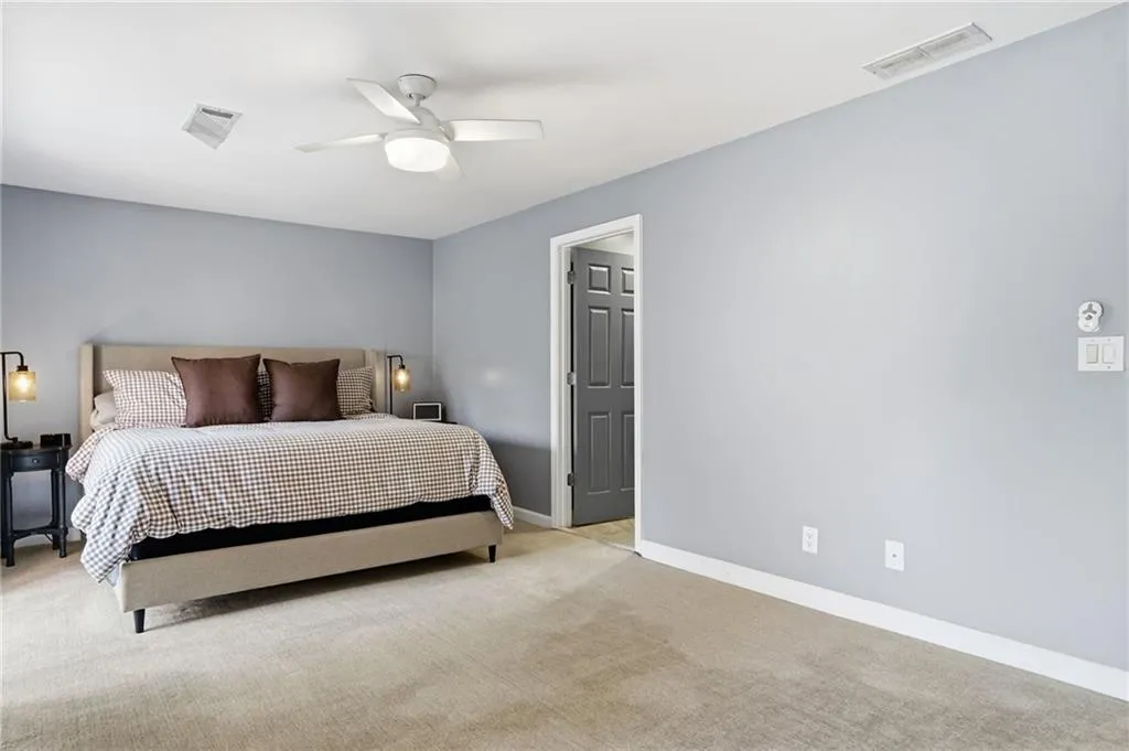 Bedroom with light carpet and ceiling fan