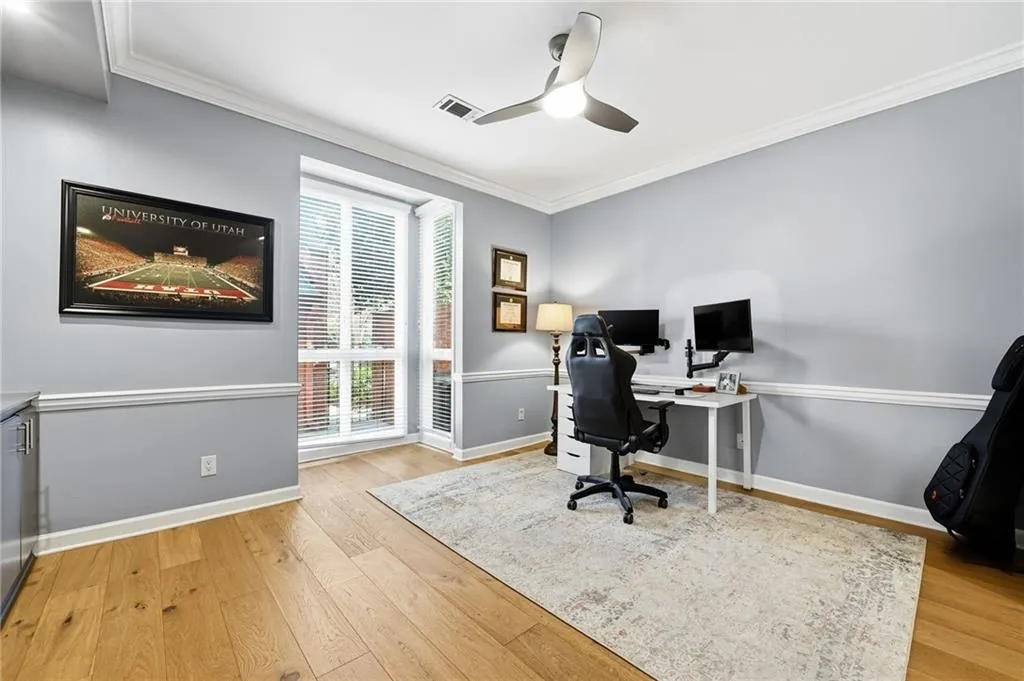 Office area featuring crown molding, a ceiling fan, and light wood finished floors