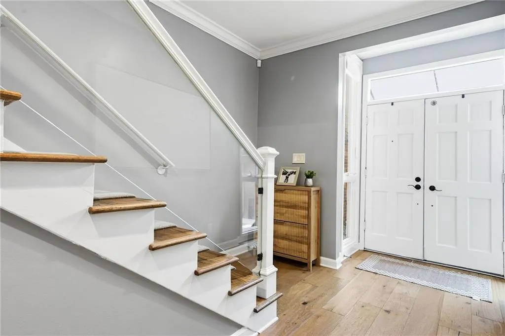 Foyer entrance featuring light wood finished floors and ornamental molding