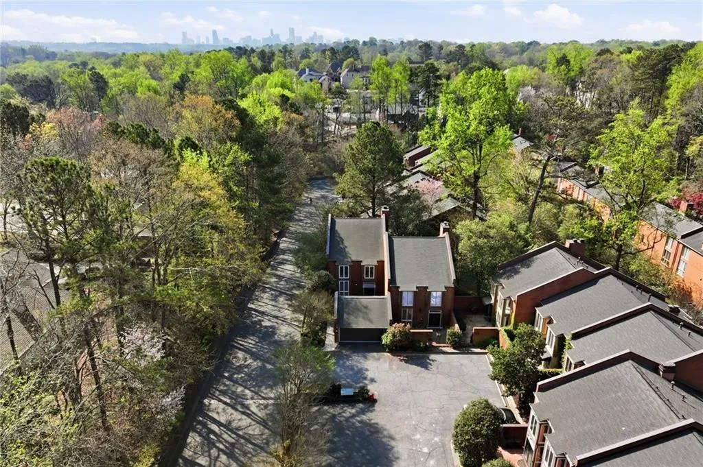 Aerial view of residential area with city skyline and a tree filled landscape
