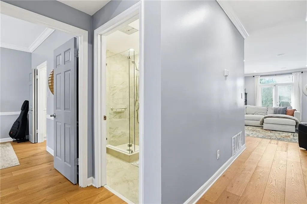 Hallway with ornamental molding and light wood finished floors
