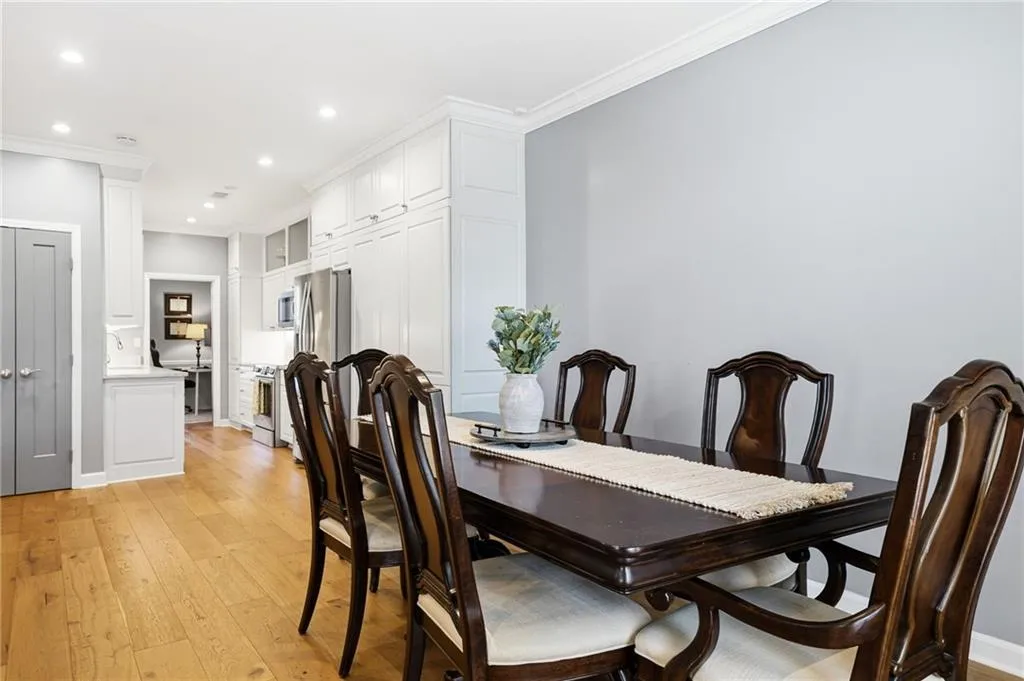 Dining space featuring light wood-style floors, ornamental molding, recessed lighting, and ornate columns