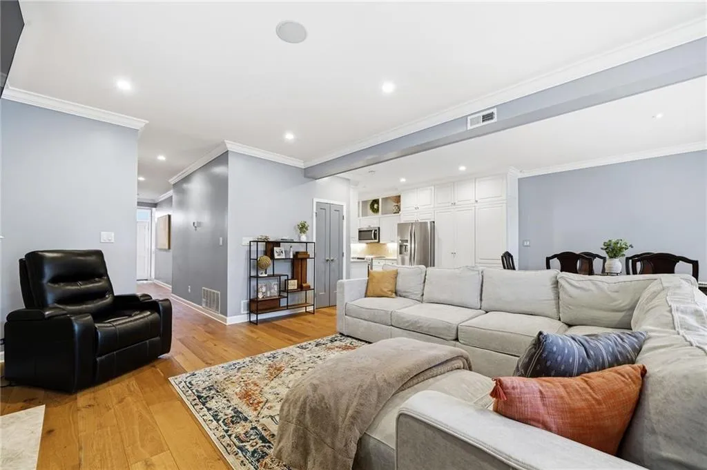 Living room featuring light wood-style floors, ornamental molding, and recessed lighting