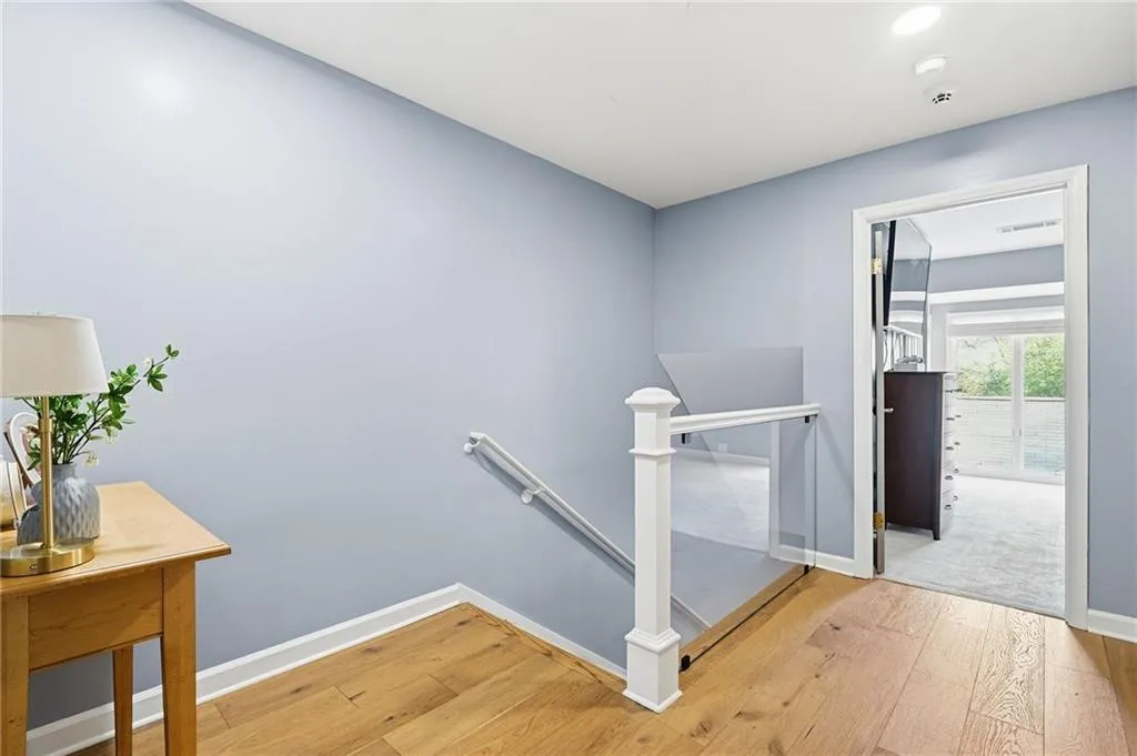 Staircase with hardwood / wood-style flooring and baseboards