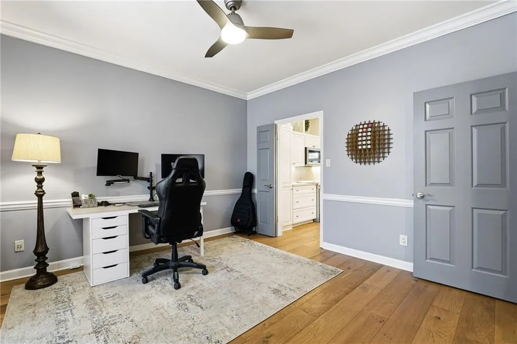 Office area featuring ornamental molding, light wood-style floors, and ceiling fan