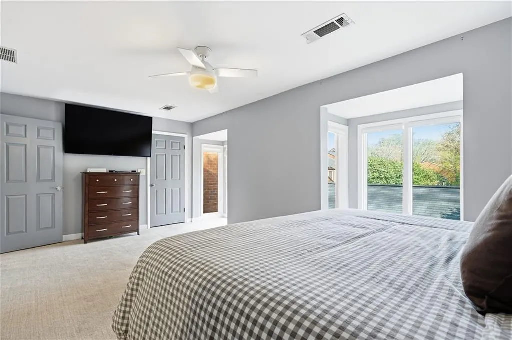 Bedroom with light carpet, a ceiling fan, and access to exterior