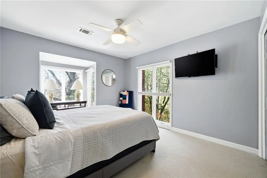 Carpeted bedroom featuring baseboards and ceiling fan