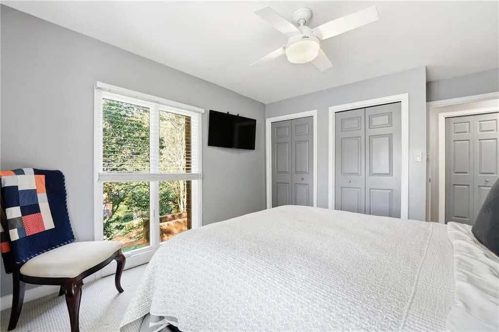 Bedroom featuring multiple closets, carpet flooring, and ceiling fan