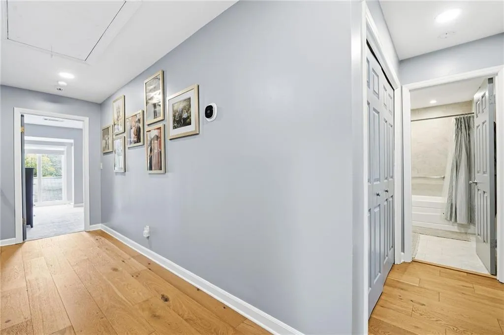Hallway with light wood-type flooring and recessed lighting