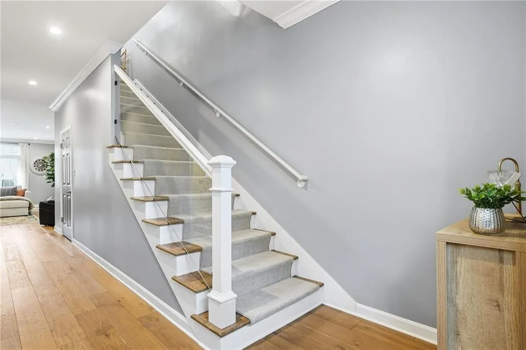 Stairs with hardwood / wood-style flooring, ornamental molding, and recessed lighting
