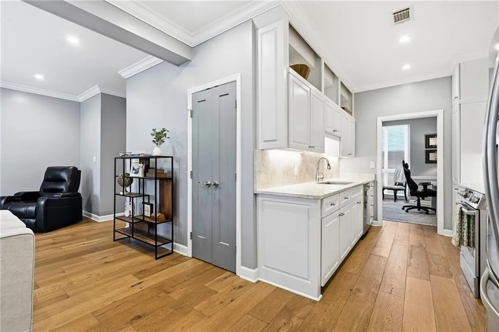 Kitchen with a desk, white cabinetry, recessed lighting, light wood-style flooring, and light stone countertops