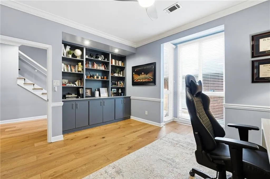 Office featuring crown molding, light wood finished floors, ceiling fan, and built in shelves