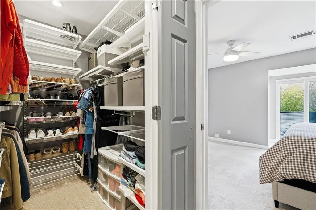 Walk in closet featuring light carpet and a ceiling fan