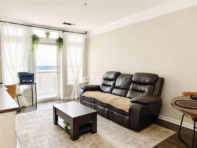 Light-toned walls, crown molding, and wood-finish flooring