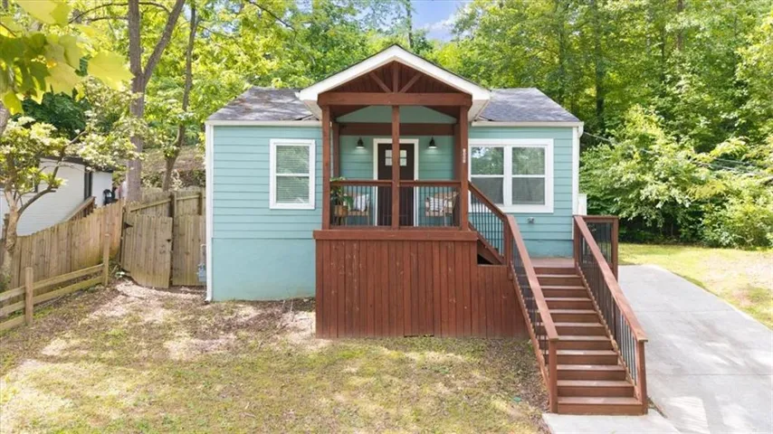Light blue exterior with white trim windows and a covered wooden porch