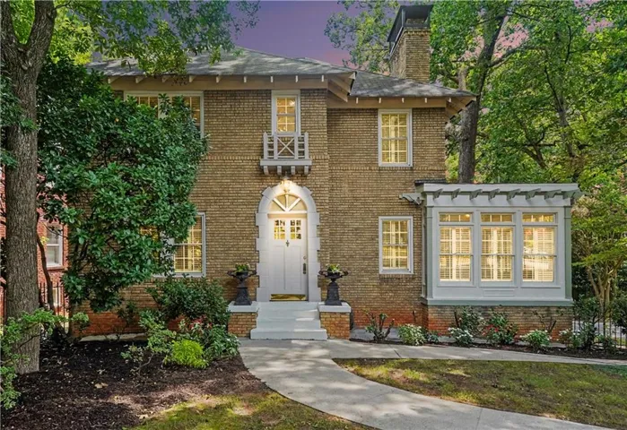 Brick exterior with a prominent arched entry, transom window, and white door