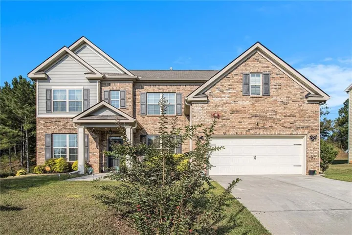 Brick and siding exterior with gabled rooflines, covered entry, and an attached two-car garage