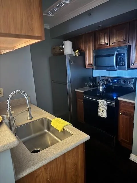 Kitchen featuring sink, fridge, range, and ornamental molding