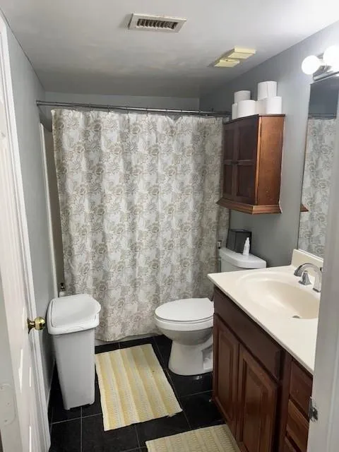 Bathroom featuring tile patterned flooring, vanity, and toilet