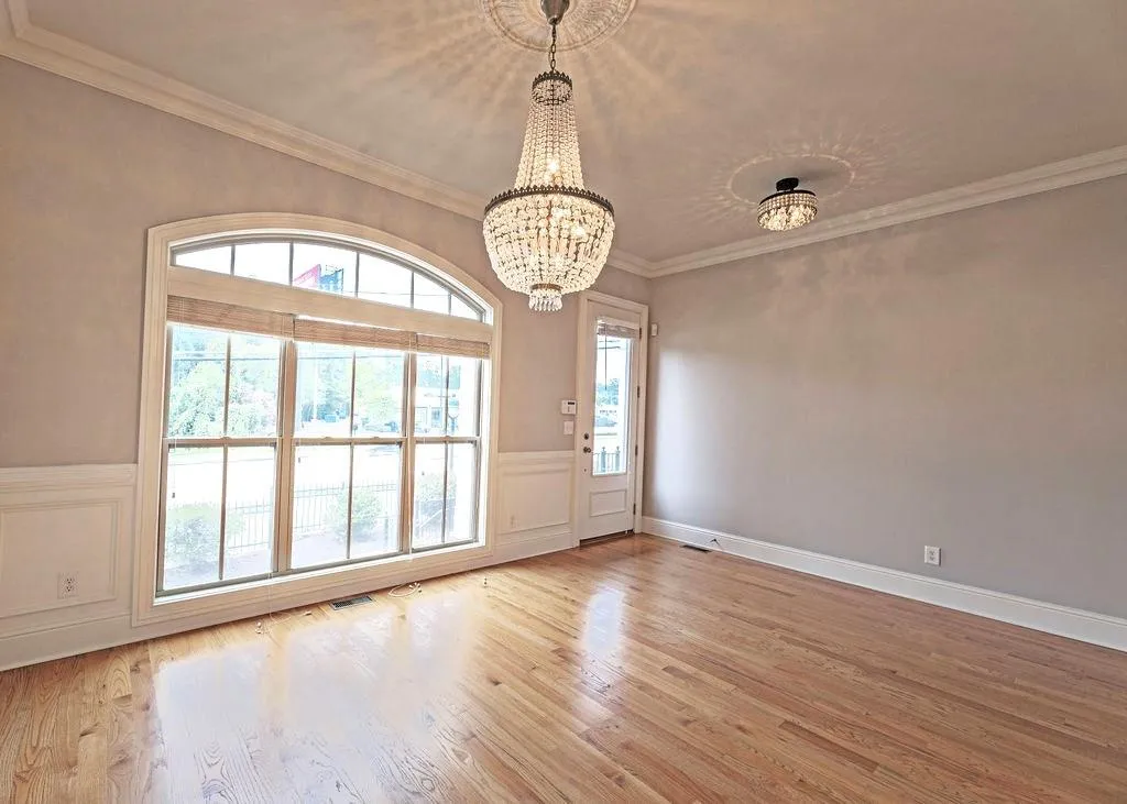 Formal Dining Room With Light Hardwood Floors, Ornamental Molding, Chandelier And Expansive Sunny, Dual Pane Window.