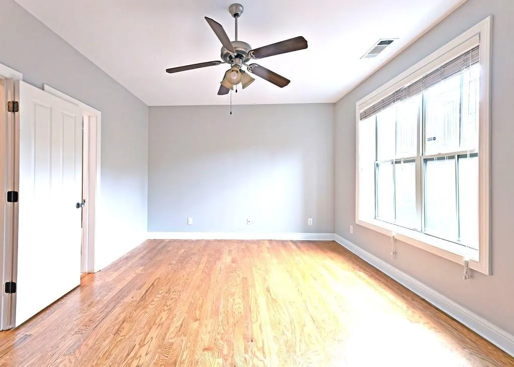 Terrance Level Bedroom With Light Hardwood Floors & Ceiling Fan.