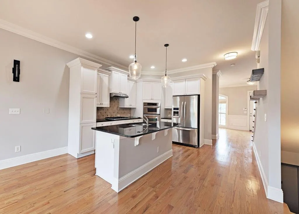 Open Plan Living/Family Room And Kitchen Area. Kitchen Featuring Crown Molding, Light Hardwood Floors, Tiled Backsplash, Huge Kitchen Island. Back Quartz Counter-Tops, And stainless Steel Appliances. Freeze/Fridge Stays!