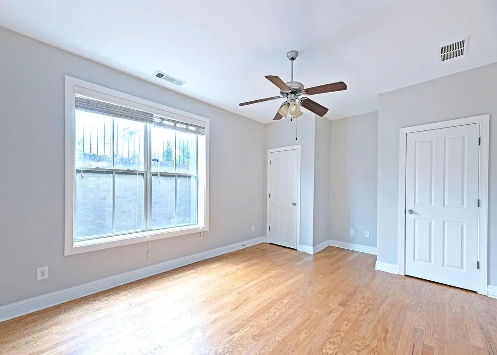 Terrance Level Bedroom With Light Hardwood Floors & Ceiling Fan.