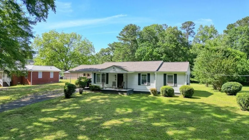 Ranch-style house with a front yard and a porch